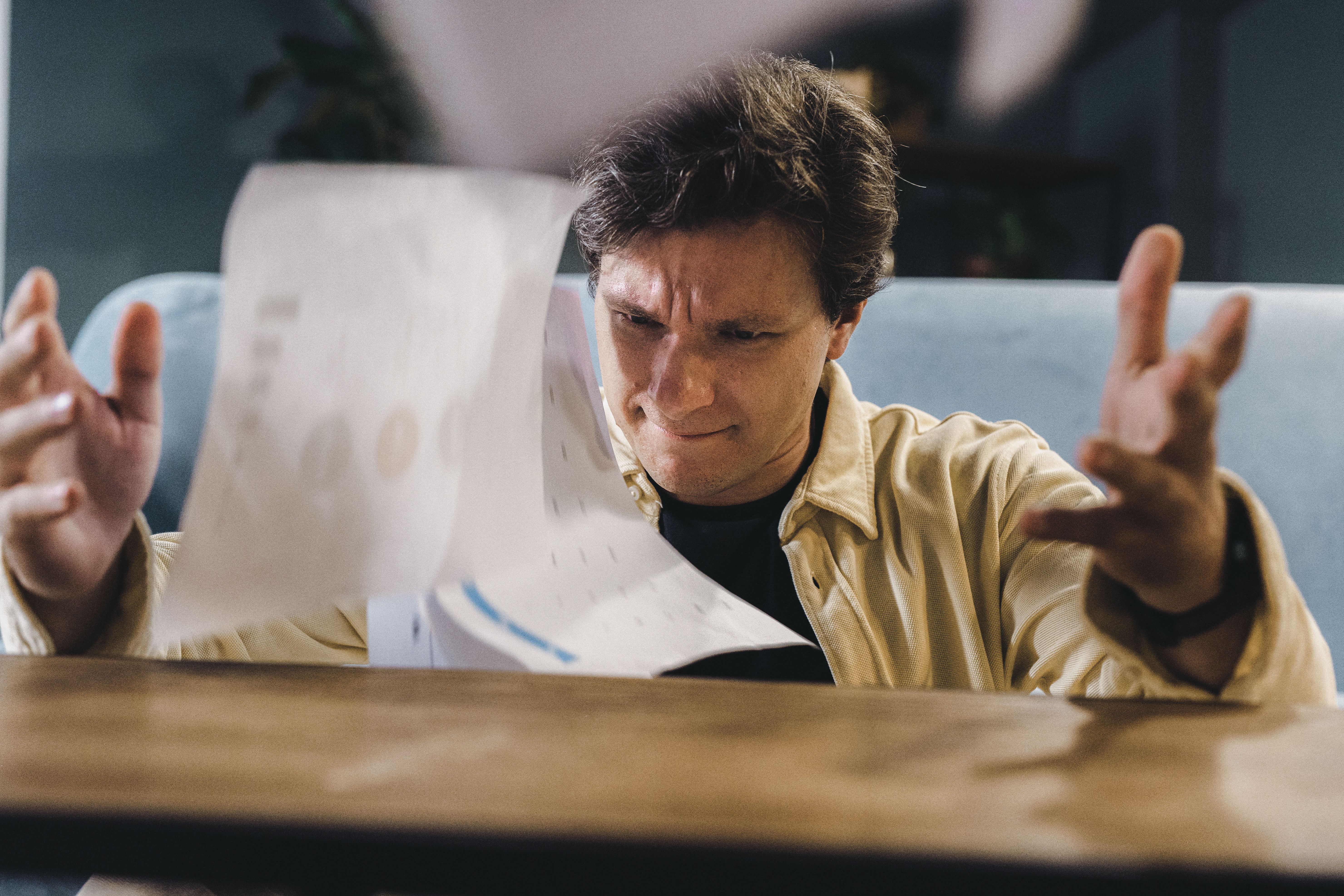 Frustrated man throwing documents at a desk, depicting the stress of a prolonged lawsuit
