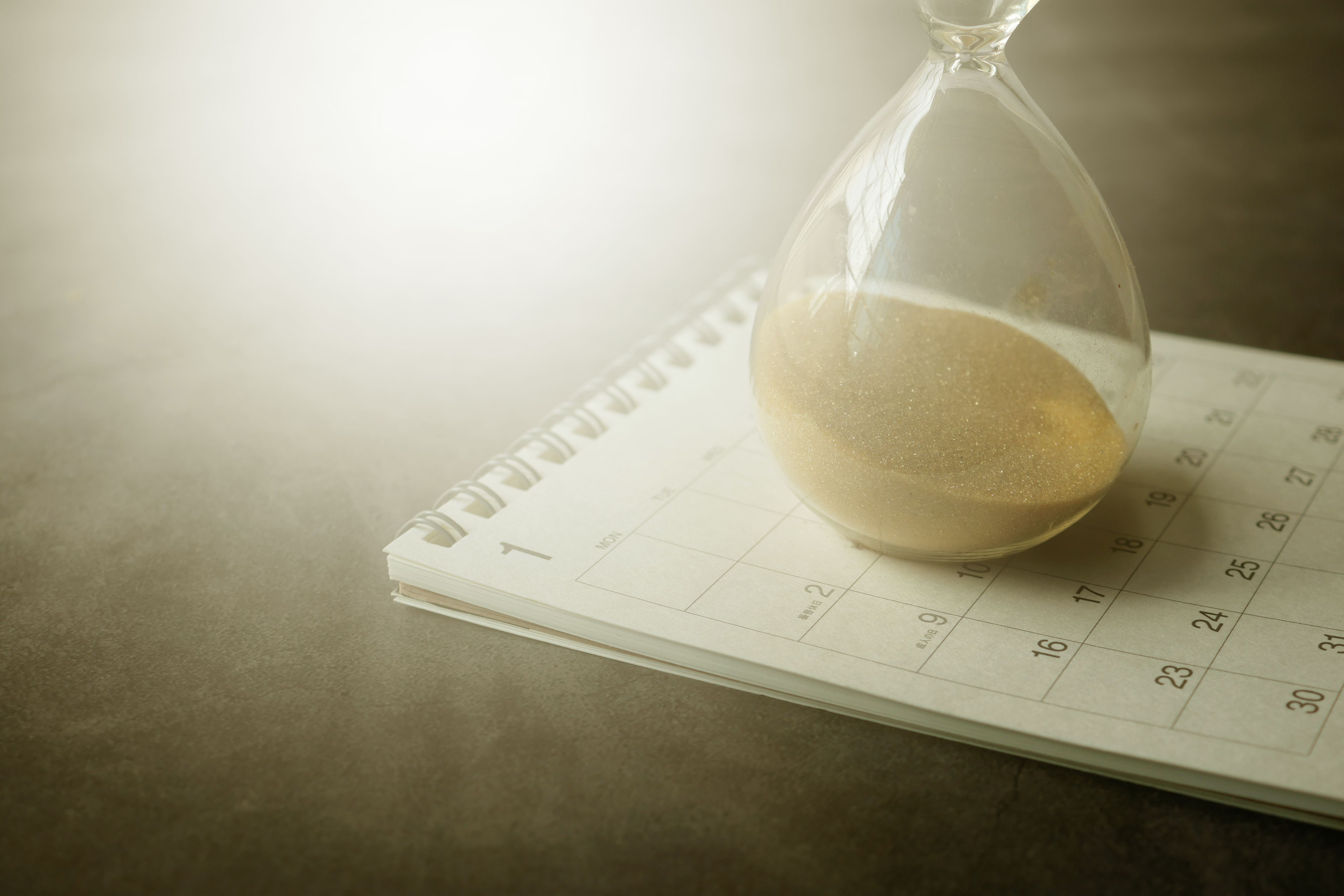 Hourglass resting on a calendar, illustrating how major lawsuits can take years to resolve