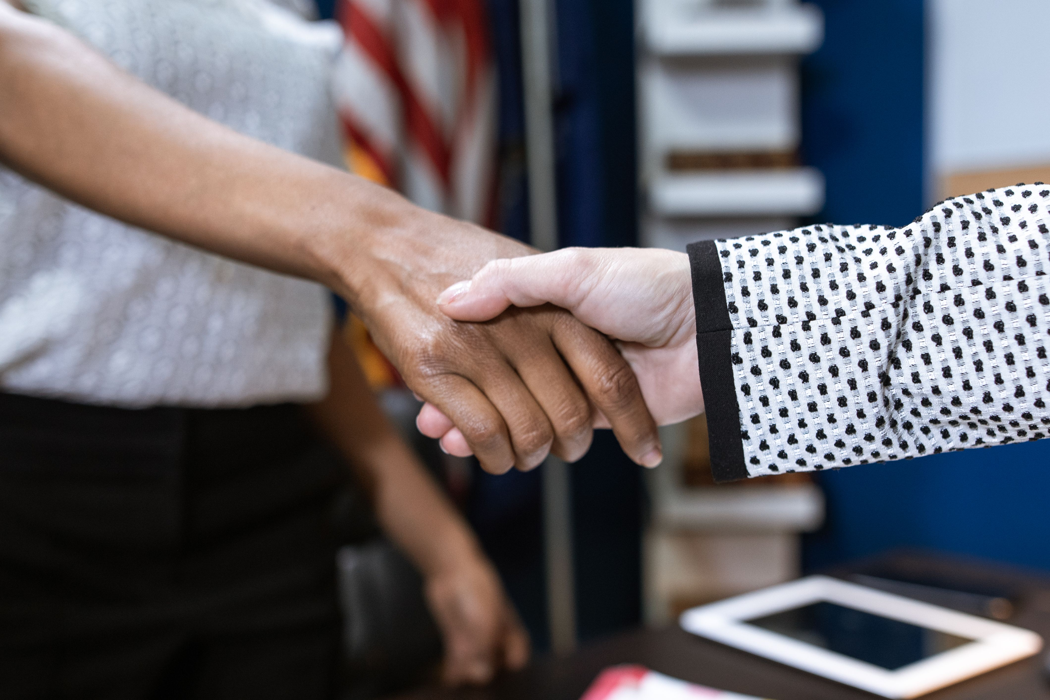 Close-up of two professionals shaking hands to finalize a legal settlement negotiation